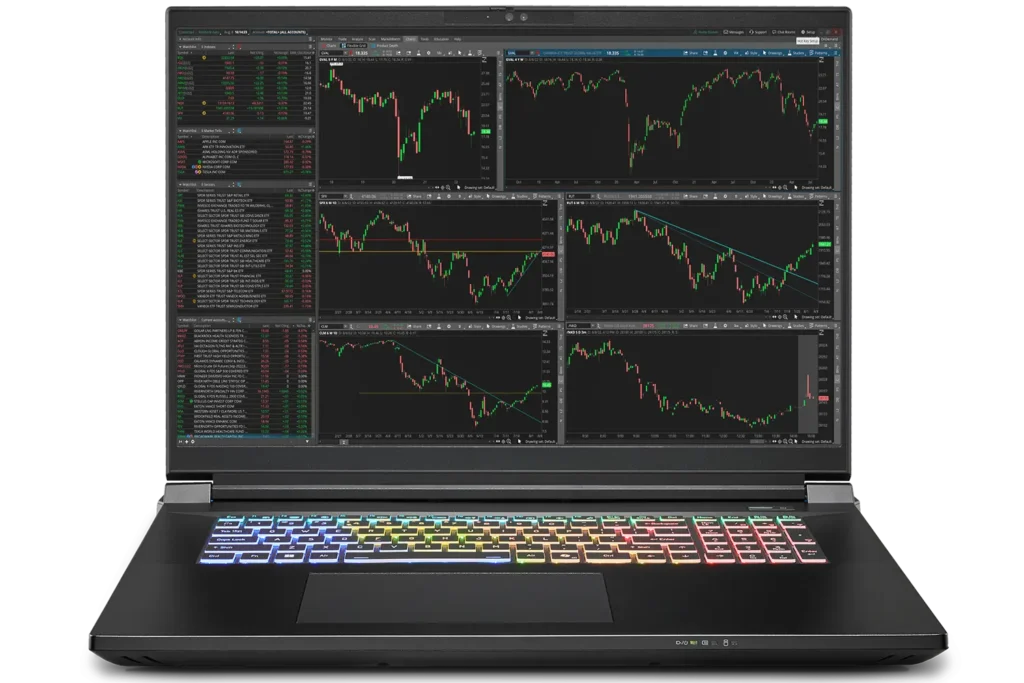 Falcon Preferred F-30 Extreme Trading Laptop displaying multiple stock charts with RGB backlit keyboard and multi-monitor trading setup.